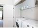 Bright laundry room featuring a white washer and dryer, storage shelves, and a doorway to another room at 9521 Ainslie Downs St, Charlotte, NC 28273