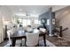 Bright open concept living room with dark floors, dining table, and staircase adjacent to the main living space at 9521 Ainslie Downs St, Charlotte, NC 28273