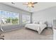Bedroom with plush carpeting, a ceiling fan, bright windows, and a dedicated desk area at 9639 Ravenscroft Nw Ln, Concord, NC 28027