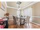 Elegant dining room with modern lighting fixture, neutral tones, and ample seating for guests at 9639 Ravenscroft Nw Ln, Concord, NC 28027
