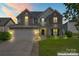 Charming two-story home featuring a stone-accented facade, well-manicured lawn, and attached two-car garage at 9639 Ravenscroft Nw Ln, Concord, NC 28027