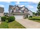Beautiful home exterior with a three-car garage, stone accents, and manicured landscaping, showcasing its curb appeal at 9639 Ravenscroft Nw Ln, Concord, NC 28027