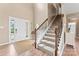 Inviting foyer with hardwood floors, staircase with wooden railing, and neutral paint colors at 9639 Ravenscroft Nw Ln, Concord, NC 28027