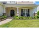 Charming front porch with stone accents and a well-manicured lawn, enhancing the curb appeal of the home at 9639 Ravenscroft Nw Ln, Concord, NC 28027