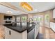 Bright, open kitchen with stainless steel appliances, mosaic backsplash, dark countertops, and center island at 9639 Ravenscroft Nw Ln, Concord, NC 28027