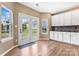 Bright breakfast nook with white cabinets, a mosaic backsplash, dark countertops, wood-look floors, and lots of natural light at 9639 Ravenscroft Nw Ln, Concord, NC 28027