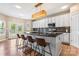 Bright kitchen with white cabinets, a mosaic backsplash, dark countertops, a center island, and stainless steel appliances at 9639 Ravenscroft Nw Ln, Concord, NC 28027