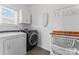 Functional laundry room with modern washer and dryer and storage shelving at 9639 Ravenscroft Nw Ln, Concord, NC 28027