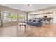 Open-concept living room features hardwood floors, large windows, and a modern kitchen with a breakfast bar at 9639 Ravenscroft Nw Ln, Concord, NC 28027