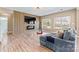 Stylish living room with a modern fireplace, wood-look flooring, a cozy couch, and plenty of natural light at 9639 Ravenscroft Nw Ln, Concord, NC 28027