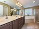 Spacious bathroom featuring a double sink vanity, soaking tub, and a glass-enclosed shower at 9700 Ravenscroft Nw Ln, Concord, NC 28027
