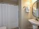 Bright bathroom featuring a sink with a pedestal and a shower with a white shower curtain at 9700 Ravenscroft Nw Ln, Concord, NC 28027