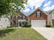 Traditional two-story brick home with well-maintained lawn and attached two-car garage at 9700 Ravenscroft Nw Ln, Concord, NC 28027