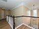 This hallway features white railings with black accents and hard wood floors overlooking the living area at 9700 Ravenscroft Nw Ln, Concord, NC 28027