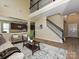 Inviting living room with soaring ceilings, staircase, and view into the adjacent modern kitchen at 9700 Ravenscroft Nw Ln, Concord, NC 28027