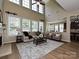 Bright living room with high ceilings, large windows, and comfortable seating area at 9700 Ravenscroft Nw Ln, Concord, NC 28027
