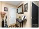 Inviting foyer featuring a decorative mirror, console table, artwork, neutral wall color, and a patterned rug at 9718 Eagle Feathers Dr, Charlotte, NC 28214