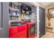 Laundry room with red washer and dryer and custom storage solutions at 9718 Eagle Feathers Dr, Charlotte, NC 28214
