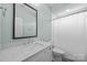 Bright bathroom with white vanity, light blue paint, large mirror, and shower at 1012 N Sharon Amity Rd, Charlotte, NC 28211