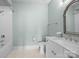 Well-lit bathroom featuring white cabinets, modern fixtures, and tiled tub with shower at 1012 N Sharon Amity Rd, Charlotte, NC 28211