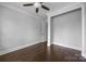 Neutral bedroom with dark hardwood floors, ceiling fan, and entry to the closet at 1012 N Sharon Amity Rd, Charlotte, NC 28211