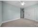 Airy bedroom with neutral paint, plush carpet, fan and spacious closet at 1012 N Sharon Amity Rd, Charlotte, NC 28211