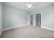 Spacious bedroom with neutral walls, carpet, a ceiling fan, and multiple doorways at 1012 N Sharon Amity Rd, Charlotte, NC 28211