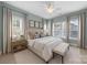 Beautiful bedroom with a neutral color palette, large bed, bench, and natural light from the two large windows at 1012 N Sharon Amity Rd, Charlotte, NC 28211