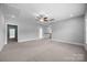 Bonus room featuring a ceiling fan, neutral carpet and walls, and multiple entryways at 1012 N Sharon Amity Rd, Charlotte, NC 28211
