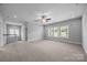Large bonus room with carpet flooring, ceiling fan, and natural light from multiple windows at 1012 N Sharon Amity Rd, Charlotte, NC 28211