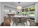 Bright dining area with stylish chandelier, hardwood floors, and seamless access to the outdoor patio at 1012 N Sharon Amity Rd, Charlotte, NC 28211