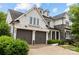 Elegant two-story home showcasing a stone and white siding exterior, a two-car garage, and a paved driveway at 1012 N Sharon Amity Rd, Charlotte, NC 28211