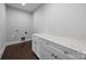 Laundry room with white cabinetry, light countertops, and dark wood floors at 1012 N Sharon Amity Rd, Charlotte, NC 28211
