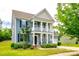 Charming two-story home featuring a covered porch, black shutters, and lush landscaping at 1044 Shiloh Bend Trl, Fort Mill, SC 29715
