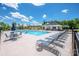 Community pool featuring a modern clubhouse, lounge chairs, and tables with umbrellas on a sunny day at 105 Chase View Ln, Troutman, NC 28166