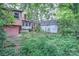 Overgrown backyard featuring multiple buildings and lush trees at 109 N Belvedere Ave, Gastonia, NC 28054