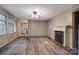 Spacious living room with hardwood floors, a fireplace, and abundant natural light from multiple windows at 109 N Belvedere Ave, Gastonia, NC 28054