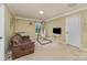 Bedroom featuring a comfortable couch, hanging chair, and modern lighting at 1105 Bottle Brush Ln, Harrisburg, NC 28075
