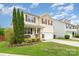 Beautiful two-story home boasts a welcoming front porch, and a well-maintained lawn at 1105 Bottle Brush Ln, Harrisburg, NC 28075