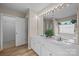 Bathroom featuring double sinks, large mirror with vanity lighting, and separate shower and tub at 12407 Crowley Ct, Charlotte, NC 28277