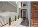Inviting entrance with manicured shrubs, a walkway, and brick accents at 12407 Crowley Ct, Charlotte, NC 28277