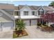 Charming townhome featuring a two-car garage, brick accents, and well-maintained landscaping at 12407 Crowley Ct, Charlotte, NC 28277