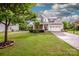 Landscaped front yard with a charming two-story home featuring stone accents and a two-car garage at 130 Bay Laurel Dr, Mooresville, NC 28115