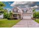 Charming two-story home boasts stone accents, a well-manicured lawn, and a spacious two-car garage at 130 Bay Laurel Dr, Mooresville, NC 28115