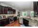 Bright kitchen with stainless steel appliances, granite countertops, and dark wood cabinets at 130 Bay Laurel Dr, Mooresville, NC 28115