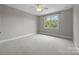 Bedroom with neutral paint, carpeted floors, and a window with views of the tree lined backyard at 14010 Mccord Rd, Huntersville, NC 28078