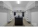 Walk-in closet with custom shelving and a center island for accessories at 14010 Mccord Rd, Huntersville, NC 28078