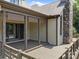View of a covered deck with a stone fireplace, wood columns, and access to the house through sliding doors at 14010 Mccord Rd, Huntersville, NC 28078