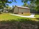 A detached two car garage with a concrete driveway, surrounded by grass and mature trees at 14010 Mccord Rd, Huntersville, NC 28078