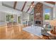 Spacious living room with a stone fireplace, wood beams, hardwood floors, and large windows at 14010 Mccord Rd, Huntersville, NC 28078